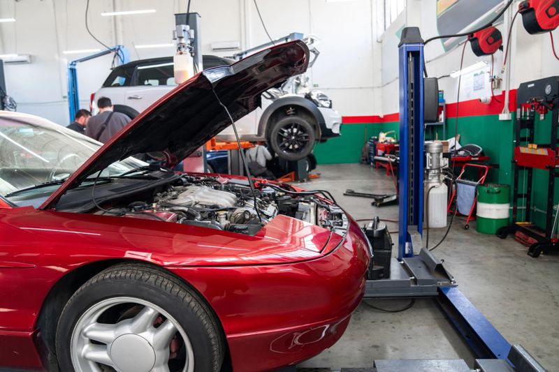 Car service workshop with cars on a column lifts.
