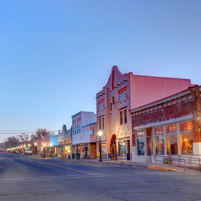 Quiet small-town street with historic buildings at dusk.