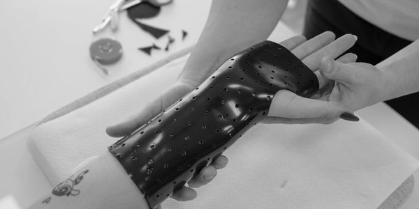 Person fitting a black perforated sleeve on an arm.