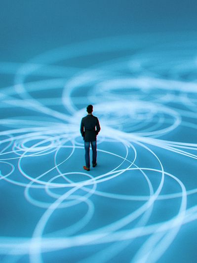A man stands surrounded by glowing interconnected blue circles and lines.