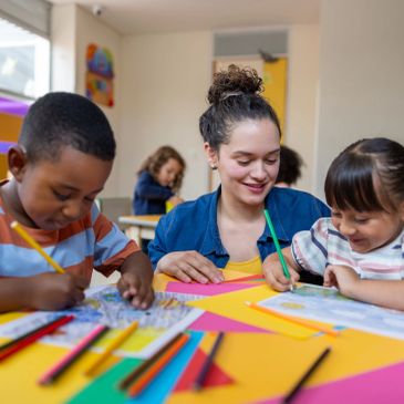 Teacher helping children with coloring.