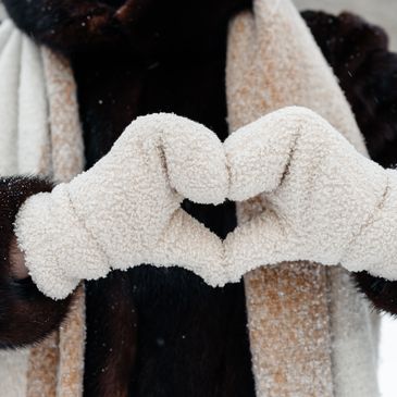 A person wearing gloves creating a heart with both hands forming a heart.