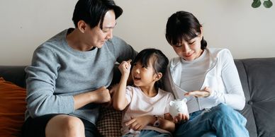 Family saving money together with a piggy bank at home.