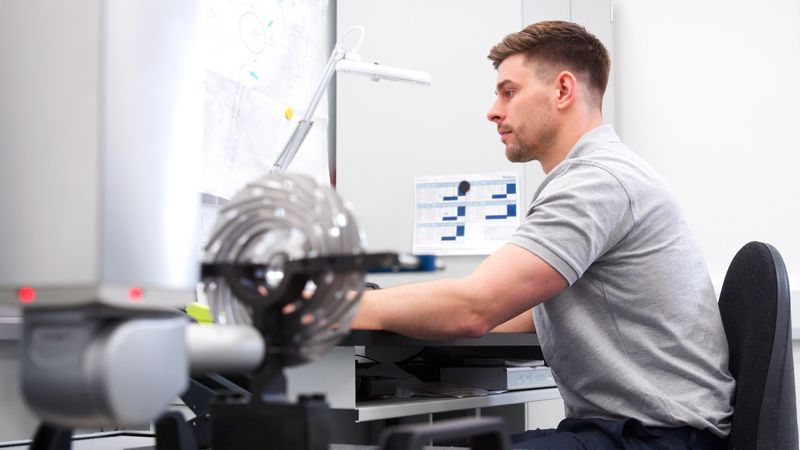 Male Engineer Uses CMM Coordinate Measuring Machine In Factory