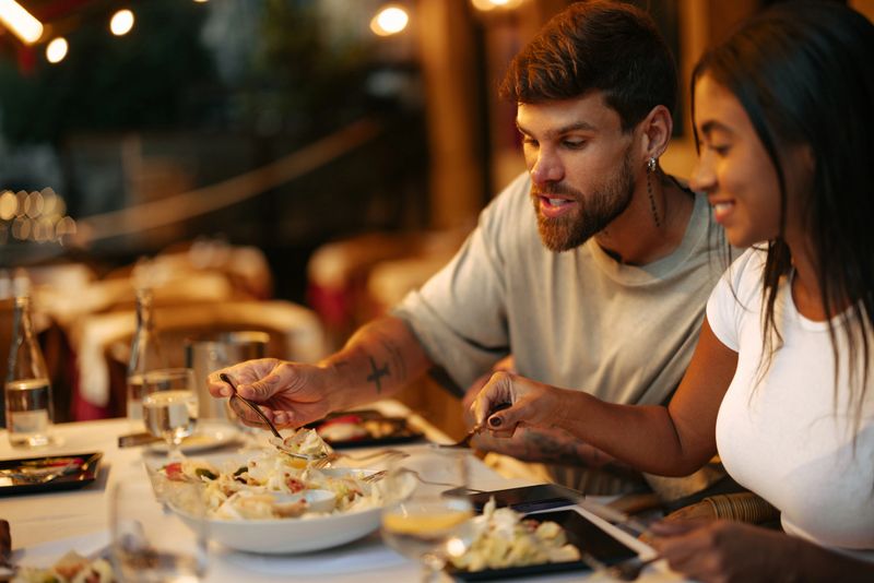 Happy couple enjoying a delicious salad at an elegant restaurant, savoring their meal and sharing joyful moments together
