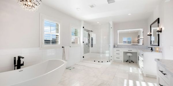 Spacious modern bathroom with a freestanding tub, glass shower, and elegant lighting.