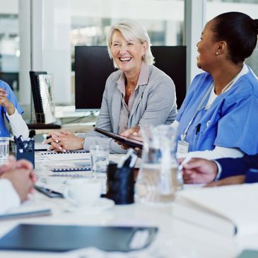 Medical team and professional smiling during a meeting in a modern office.