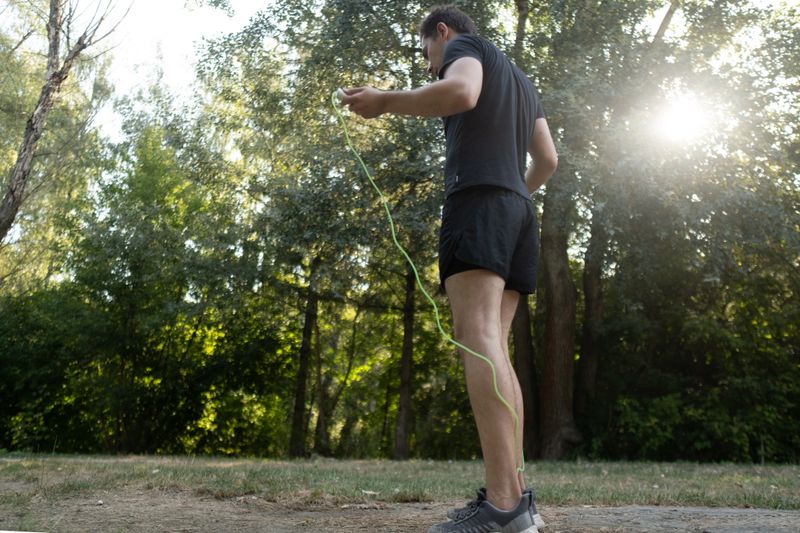 An inspiring workout: a man jumps rope in the park, boosting his endurance and physical condition.