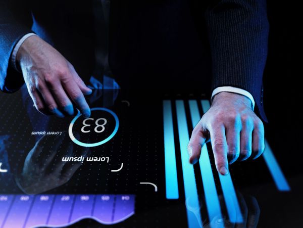 Person interacting with futuristic digital interface displaying data charts.