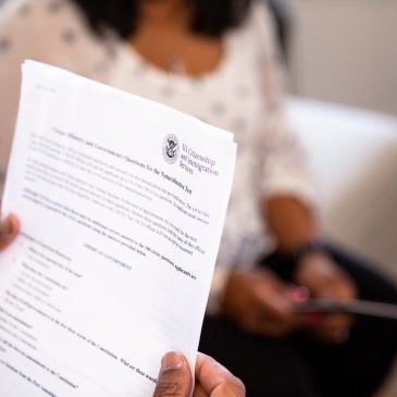 Person holding a document titled 'Your Care and Community Questions'.