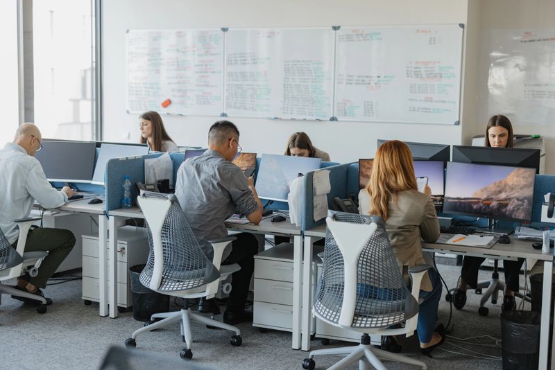 A diverse group of professionals work together in a modern office setting, highlighting collaboration, teamwork, and the shared drive for success among colleagues.