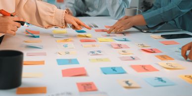 Colleagues arranging colorful planning notes to develop a customized business strategy
