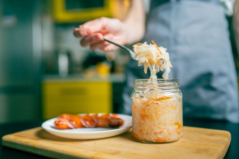 Close-up of a fork with sauerkraut and a piece of Bavarian sausage, traditional German dish