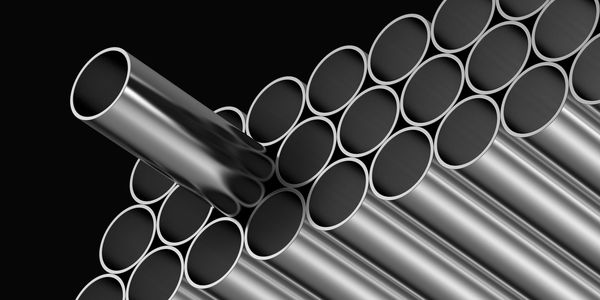 Stack of shiny metal pipes with one pipe lifted.