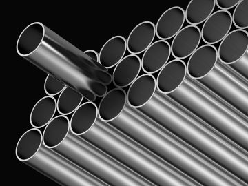 Stack of shiny metal tubes against a black background.