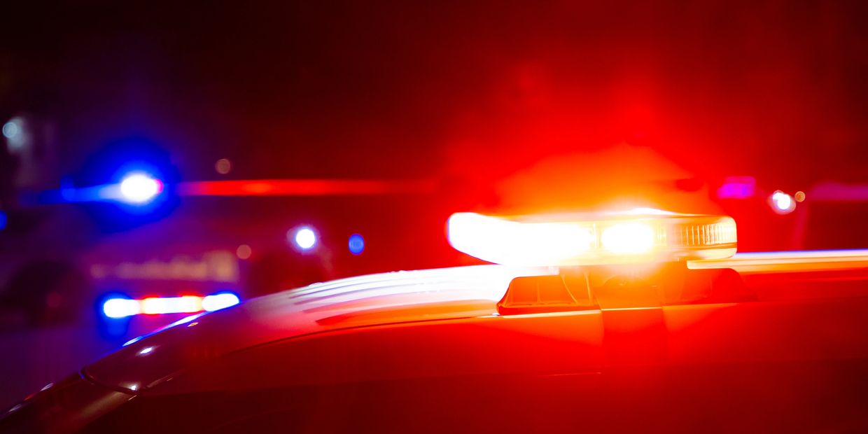 Flashing red and blue police car lights at night.