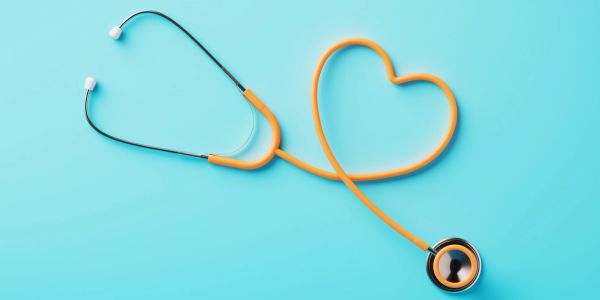 Orange stethoscope shaped like a heart on blue background.