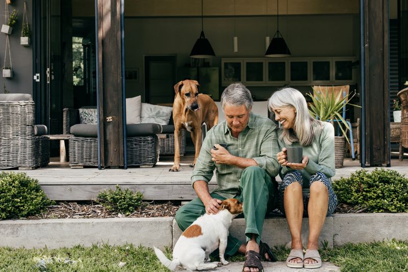 The warmth of companionship shines as a couple in their 60s enjoys a slow morning, sipping coffee in the fresh air.