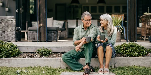 Glückliche Rentner vor ihrer bezahlten Immobilie
