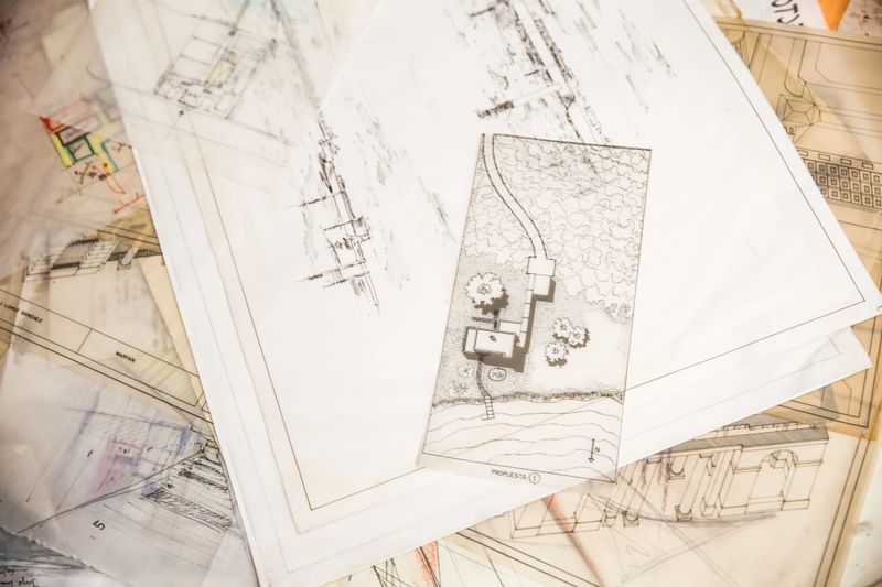 Various architectural drawings displayed from a top view, detailing the intricate plans for a construction project. Highlights meticulous design, structural blueprints, and comprehensive planning for a building.