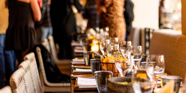 Elegant table setting with glasses and candles at a social gathering.