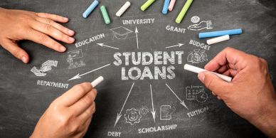 Hands holding chalk around student loans diagram on a blackboard.