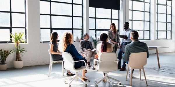 A diverse team engaged in a meeting in a bright modern office.