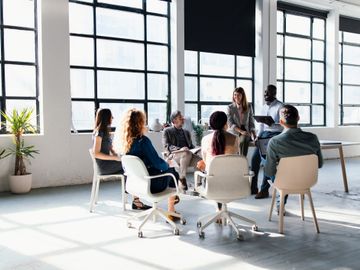 A diverse team engaged in a meeting in a bright modern office.