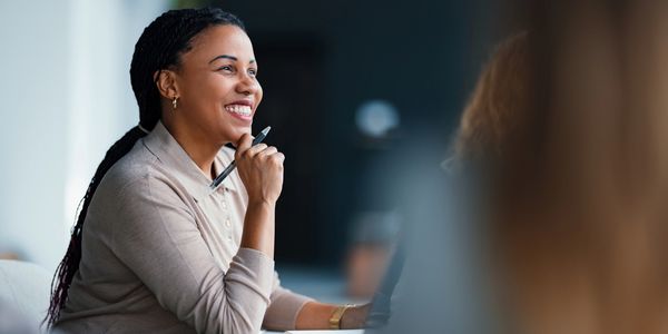 Smiling woman attentively listening during a meeting.