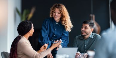Three colleagues engaged in a lively discussion at work.