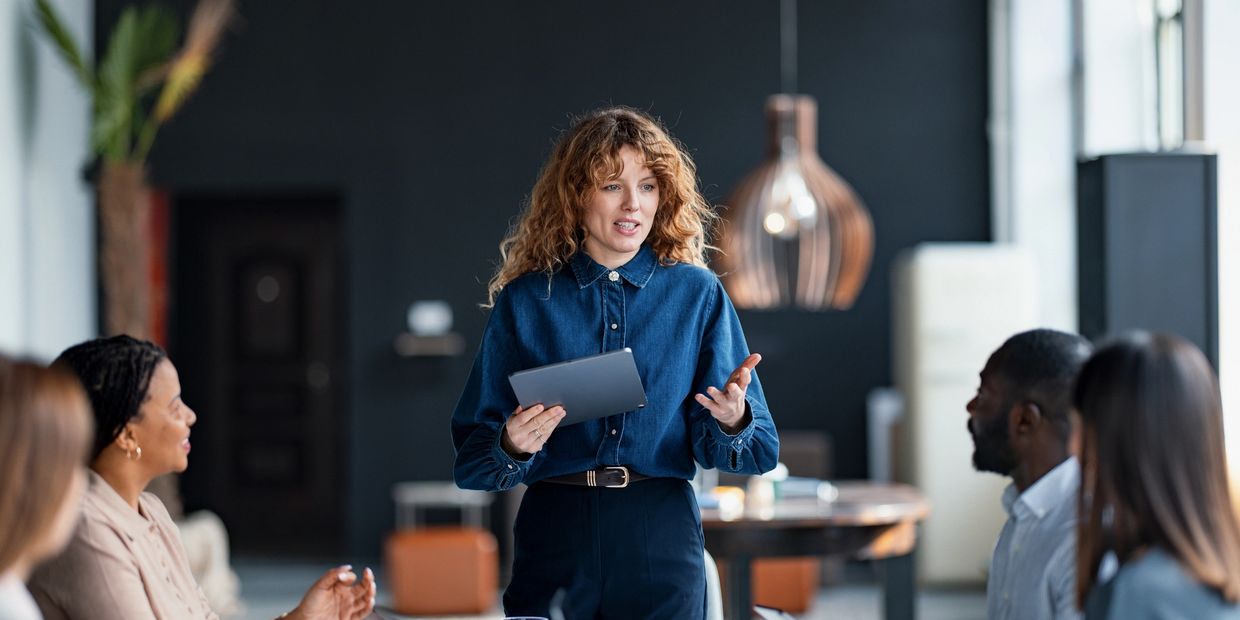 Woman leading a discussion with colleagues in a modern office.