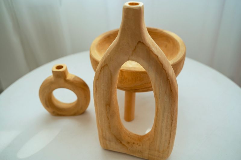 three wooden light beige decorative pots. different shapes wooden tableware. eco tableware, handmade stands on a white table. horizontal photo, close-up