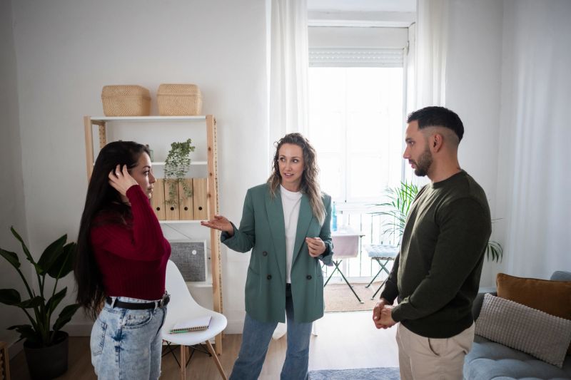 Real estate agent showing new apartment to a young couple, explaining the characteristics of the property