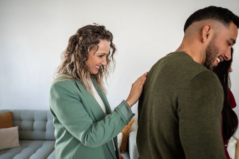 Smiling real estate agent patting a young man on the back after closing a deal on a new home