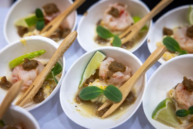 Elegant gourmet appetizers meticulously arranged in white ceramic bowls, showcasing fine dining, culinary artistry, and luxury catering at an upscale event.