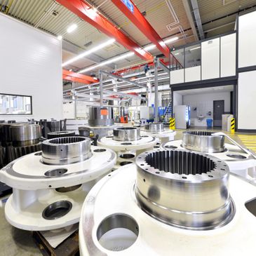 Large metallic industrial components in a clean factory setting.