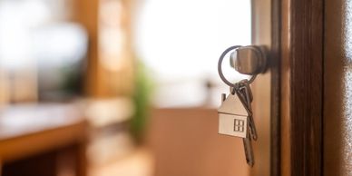 House key with keychain in a door lock.