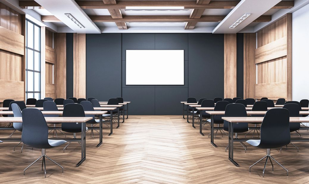 Modern classroom with rows of desks and black chairs.