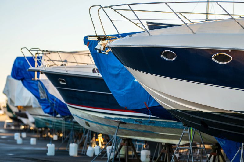 luxury boats stored on stands at marina dockyard.