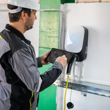 Technician working on electric vehicle charging station.