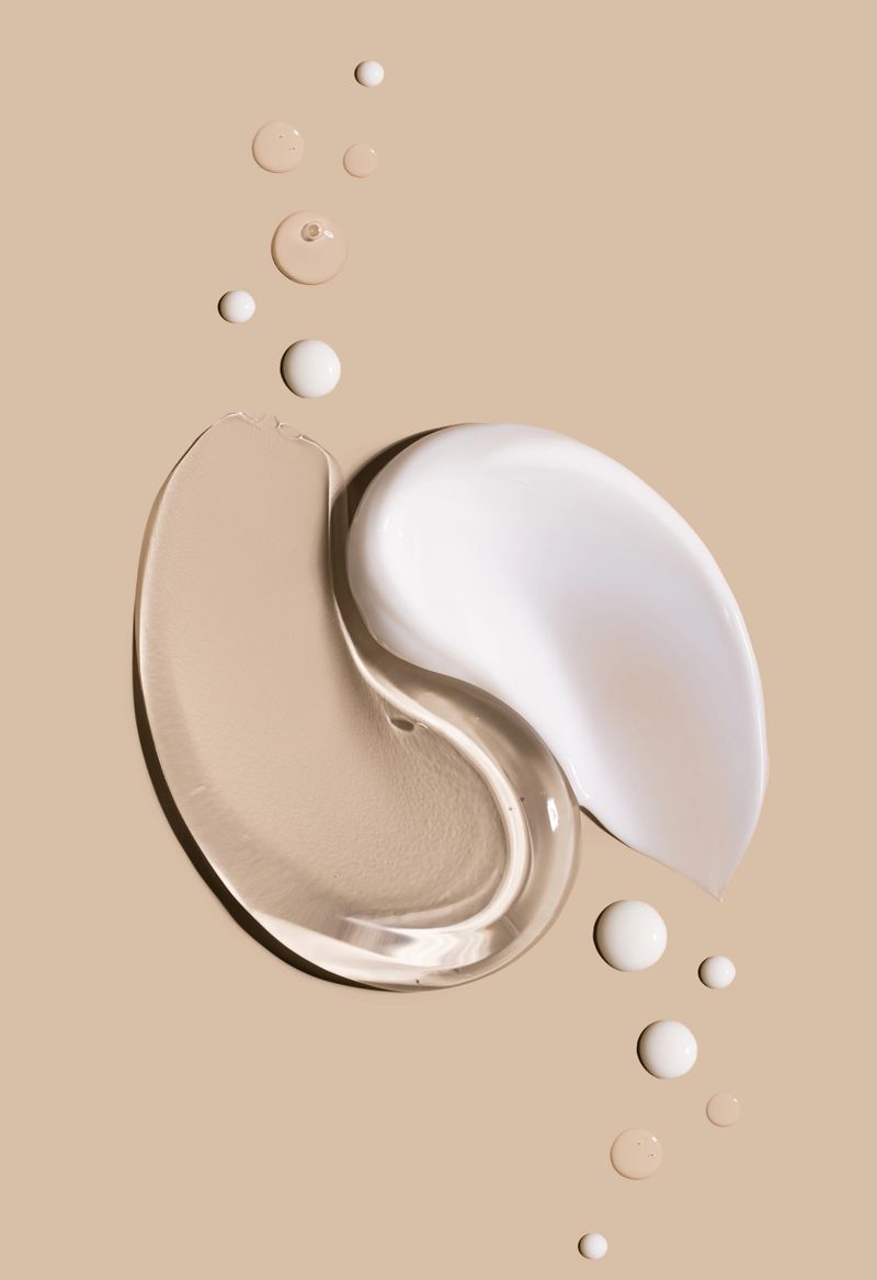 smears of creamy white texture cosmetic sample close up on beige background