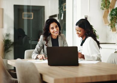 Two women discussing work in an office.