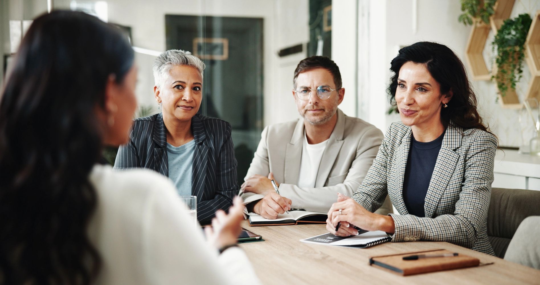 Three professionals attentively listening during a meeting or interview.