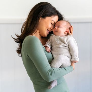 Young mom holding her newborn baby.