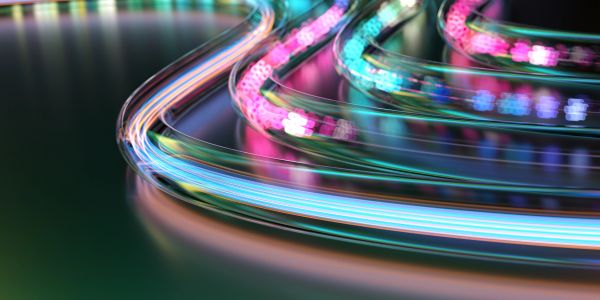 Colorful neon light trails curving smoothly on a dark surface.