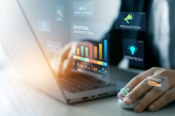 Person working on digital marketing strategies using a laptop and virtual data charts.