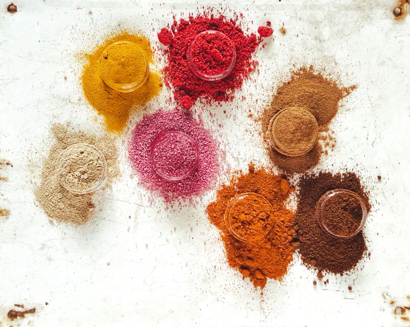 Anti-inflammatory spices relieving health problems, directly above shot of cardamom, common beet, turmeric, paprika, sumac, clove powder and cinnamon in plate on wooden table, various spices with health benefits - healthy eating, superfood, copy space