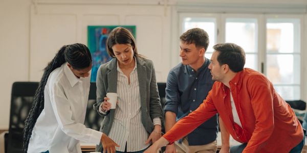 Four colleagues discussing a project around a table.