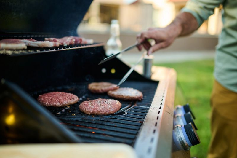 Grilling juicy steaks and hamburgers on a summer evening, creating a delicious aroma for a backyard cookout with friends and family, celebrating togetherness and special american holidays