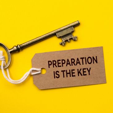 A key with a tag reading 'PREPARATION IS THE KEY'.